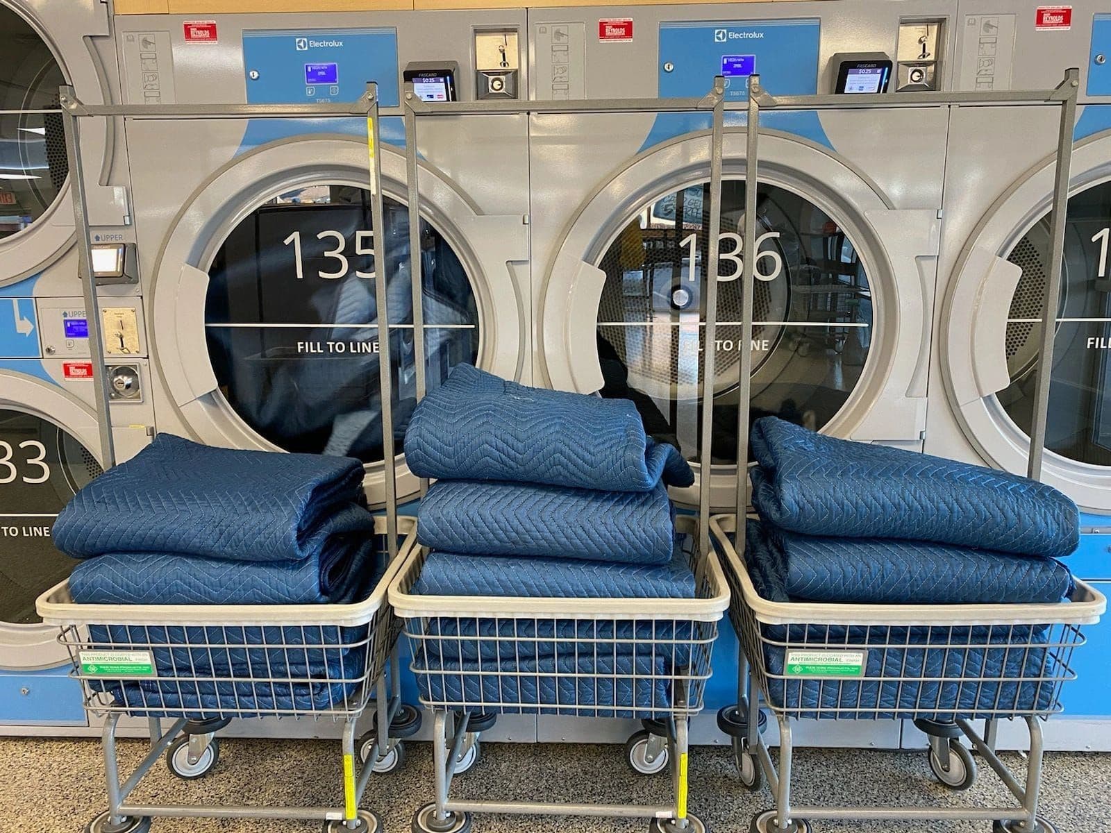 Freshly laundered moving blankets, folded in our shop