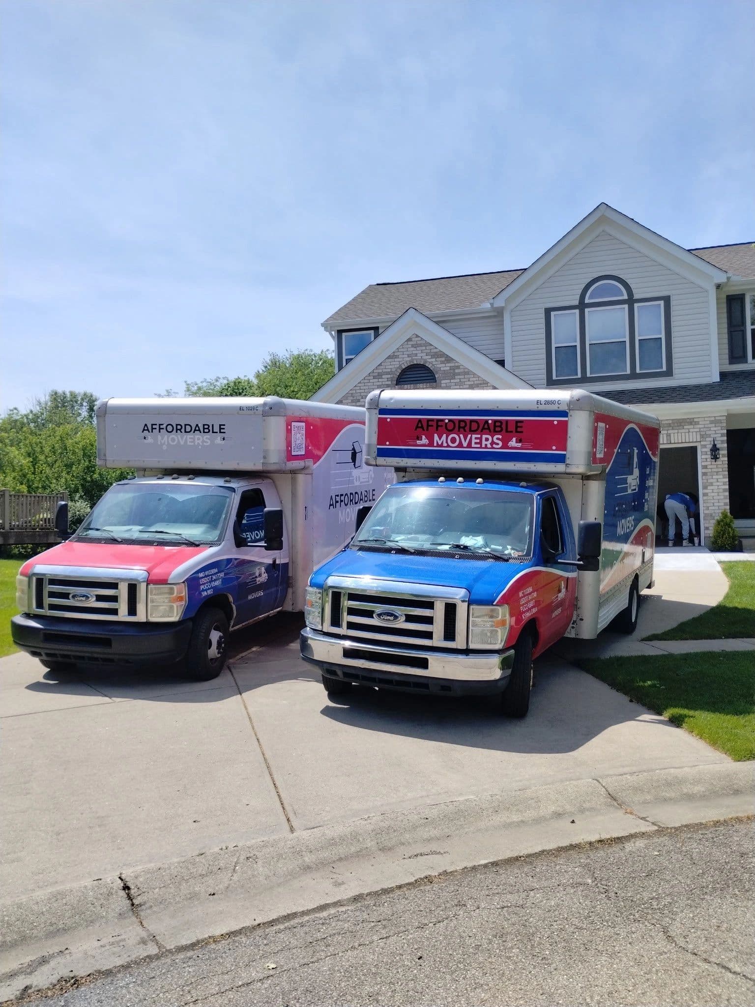 Two Affordable Movers trucks staged in a customer’s driveway on moving day